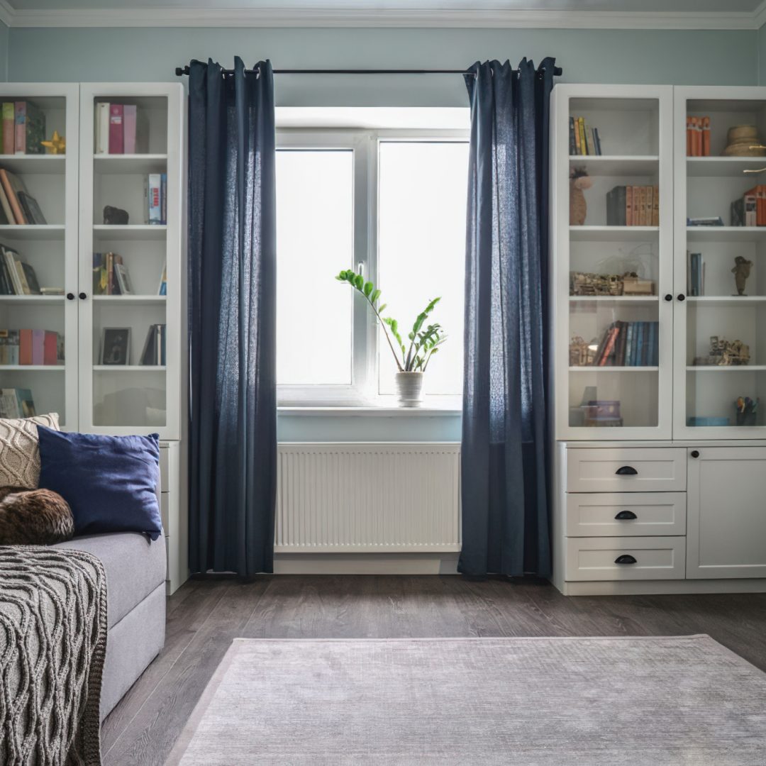 Light cozy teen room with white bookcases, grey sofa and blue walls